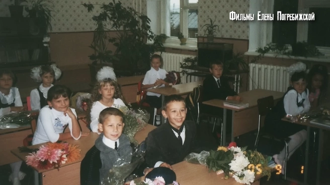 Александр в школьные годы&nbsp;— улыбающийся мальчик в черном пиджаке на переднем плане | Источник: Истории без сахара. Погребижская / YouTube