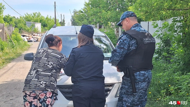 Должница подписывает документы о том, что принадлежащий ей гараж будут продавать, чтобы хоть как-то уменьшить долг по алиментам | Источник: Александр Лисихин / 45.RU 