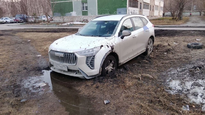 Трудно поверить, что водитель не понимала, где паркует автомобиль. Судя по переднему колесу, кроссовер&nbsp;застрял в жирной грязище | Источник: «Яндекс Драйв»