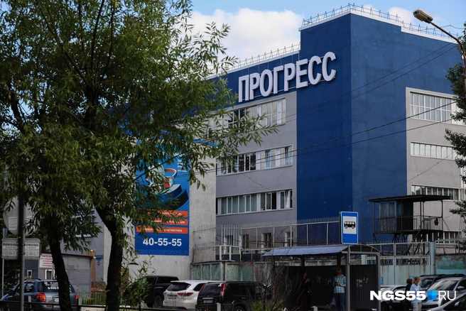 Заборы завода нависают над проходящими мимо людьми | Источник: Евгений Софийчук / NGS55.RU