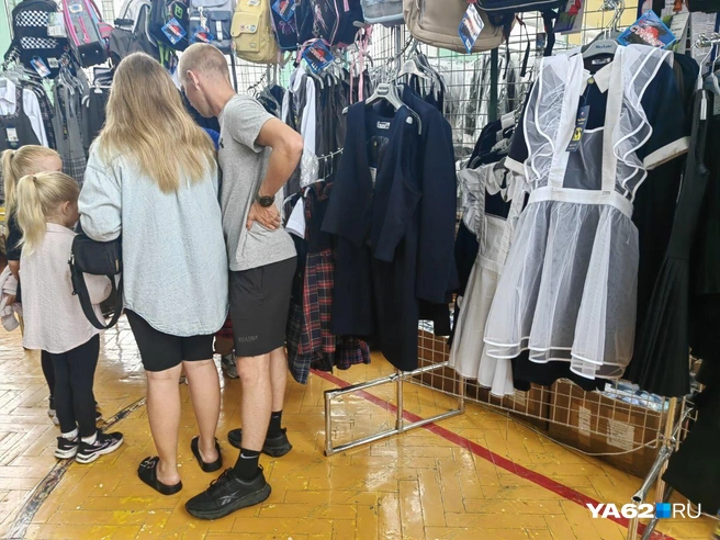 На вешалках в торговом зале висят брючные костюмы, платья, сарафаны и даже советская форма | Источник: Кристина Мельникова