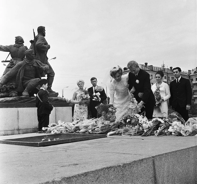 Молодожены на фоне гранитных памятников — одна из самых узнаваемых и парадоксальных визуальных примет советской эпохи | Источник: Исаак Рабинович / ТАСС