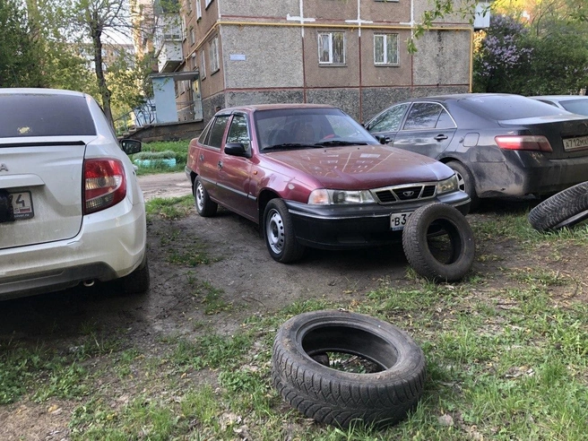 Нищие духом встают на газоне и прикрывают госномер покрышкой, чтобы защититься от «Дозора» | Источник: читатель 74.RU