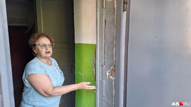 Наталья Осипова показывает неудовлетворительное состояние входных групп в подъезды | Источник: Александр Лисихин / 45.RU 