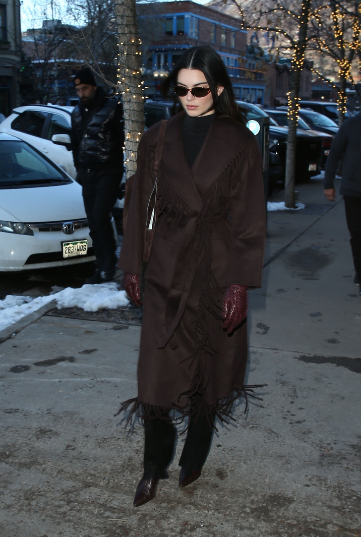 Горький шоколад: Кендалл Дженнер в коричневом пальто с бахромой и плетеных перчатках