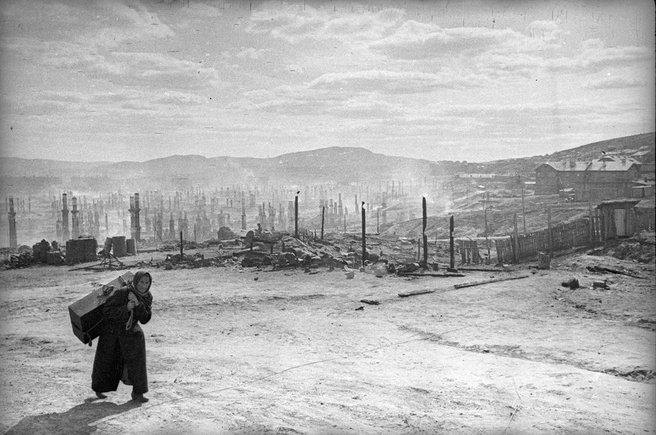 Женщина с чемоданом в июне 1942 года покидает разрушенный Мурманск | Источник: Евгений Халдей