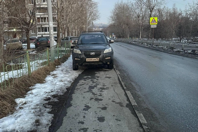 По логике этого водителя, пешеходы должны обходить его машину прямо по проезжей части (если не пролезут по сугробу возле забора) | Источник: читатель E1.RU