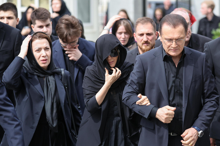 С похорон мужа Диану Гурцкую увела под черными зонтами толпа охранников