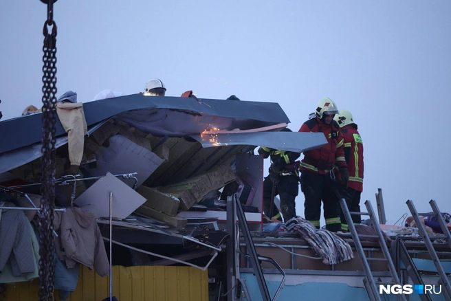 Спасатели распиливают крышу | Источник: Александр Ощепков / NGS.RU