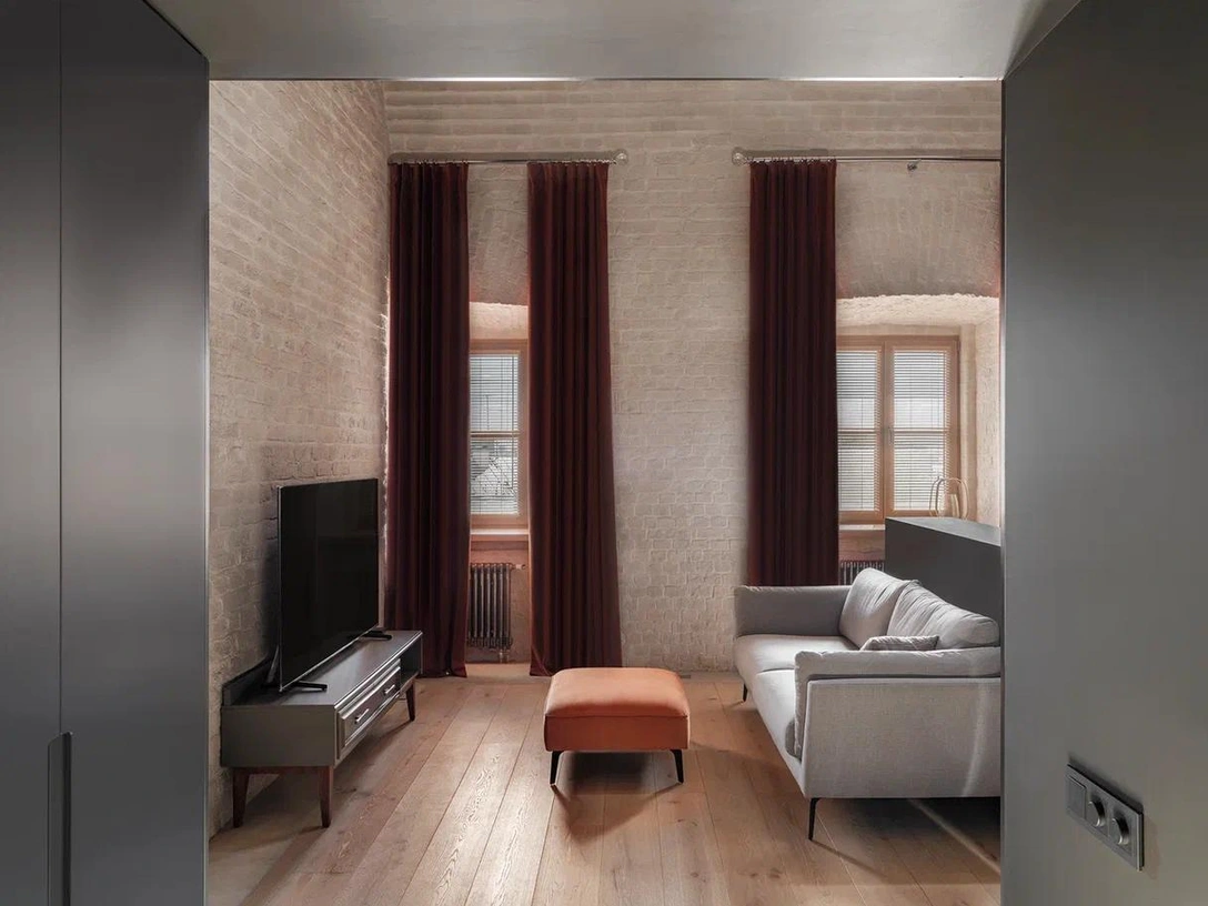 Главное украшение квартиры — старинная кирпичная кладка и четырехметровый потолок. Диван, E-style. | Источник: Дина Александрова