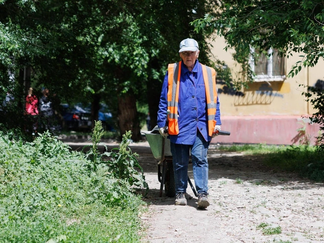 Через дорогу коммунальные службы устраняют последствия атаки | Источник: Алексей Волхонский / V1.RU