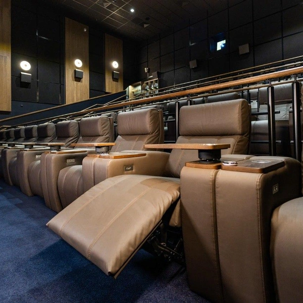 Зал оборудован премиальными креслами функцией массажа, беспроводной зарядкой для гаджетов и кнопкой вызова официанта | Источник: АО «СИНЕМА ПАРК»