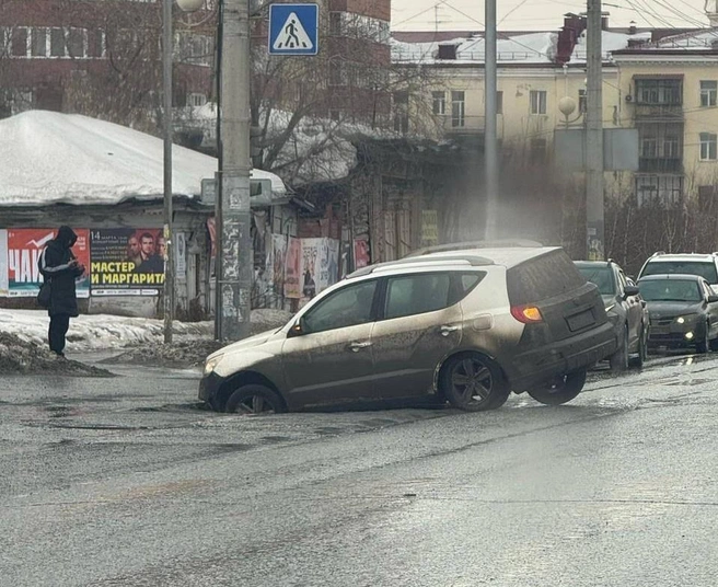 Яма настолько глубокая, что кроссовер не смог самостоятельно выехать из нее  | Источник: «Аварийный Омск» / T.me