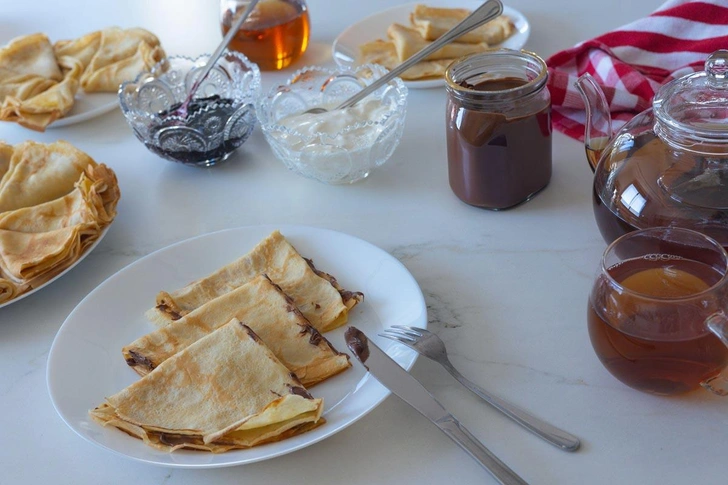 Традиционные блинчики с джемом, сметаной, шоколадной пастой и чаем | Источник: Igor Plakushchenko / Alamy via Legion Media