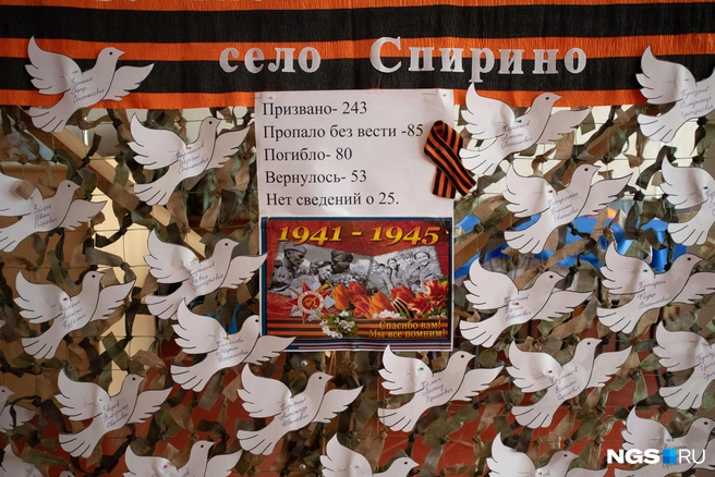 К празднику сельчане готовились загодя, еще с зимы. В фойе дворца культуры можно увидеть целую выставку — наивные детские рисунки, фотографии и вот такую инсталляцию. Имена погибших на фронтах Великой Отечественной войны бойцов написаны на бумажных голубях мира | Источник: Андрей Бортко / NGS.ru