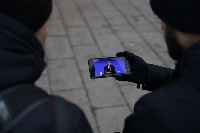Кто-то смотрит трансляцию с телефона на улице | Источник: Артём Устюжанин / MSK1.RU
