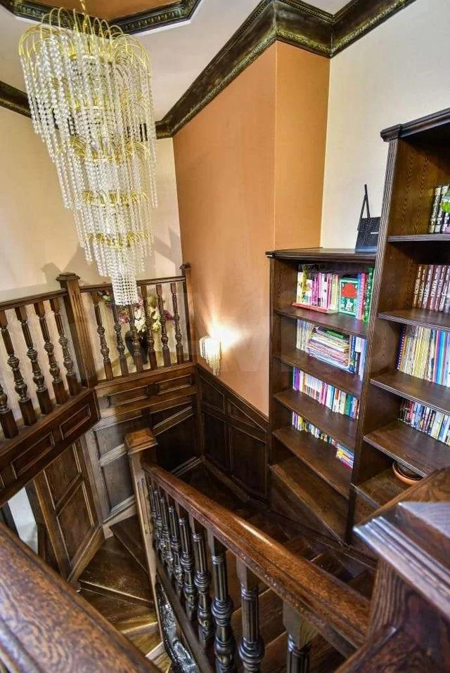 Лестница с библиотекой, позолоченные люстры с кристаллами Сваровски | Источник: Avito