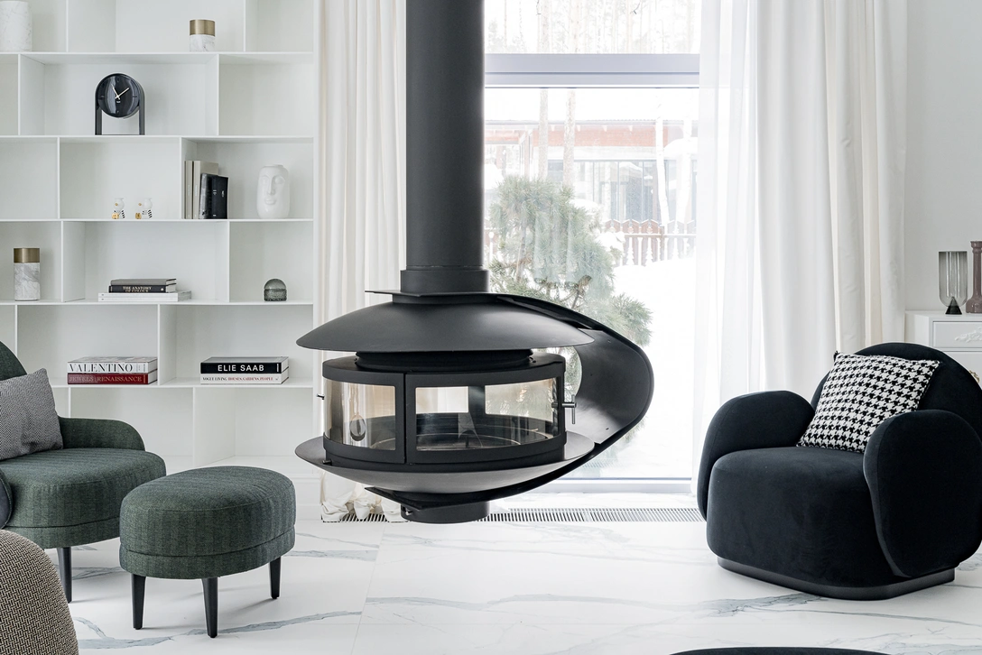 Уютная зона библиотеки с подвесным камином, где можно расслабиться после напряженного рабочего дня. Кресла и пуф, Marc. Кресло и пуф, Sisley. Комод Jasper, Azarova Home. Стеллаж сделан в ателье мебели K&A. Напольное покрытие, Laminam. | Источник: Наталия Горбунова