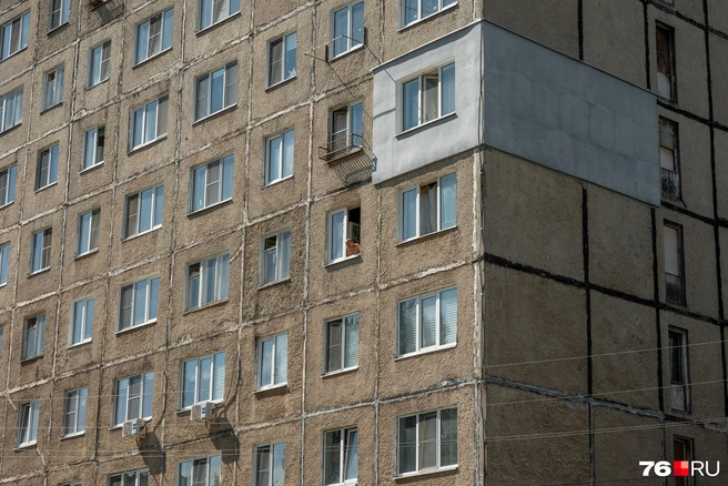 Местный житель наблюдает за двором из окна панельки | Источник: Александр Куренной / 76.RU
