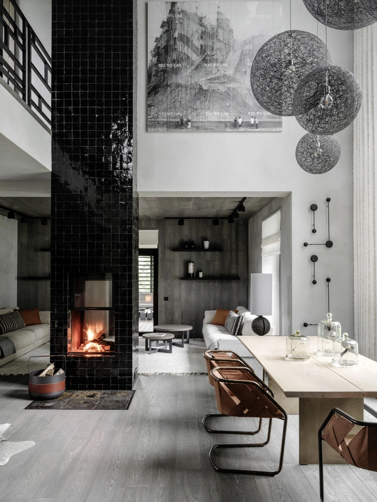Гостиная. Камин отделан бельгийской плиткой ручной работы. Стол, DK3. Стулья, Henge. На столе — инсталляции Сергея Денисова. На стене — картина Кирилла Челушкина Yes we can. Диваны, Black Tie, Populuxe, ткань, Pierre Frey. Полы, компания «Золотой Лес». На полках — керамика, купленная в Милане в галерее Антонио Марраса. Ограждение балкона второго этажа, мастерская Александра Павловского, pavlovsky.design. | Источник: Михаил Лоскутов