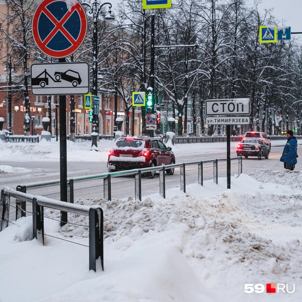 Человек на пешеходном переходе наполовину скрыт снегом | Источник: Тимофей Калмаков / 59.RU
