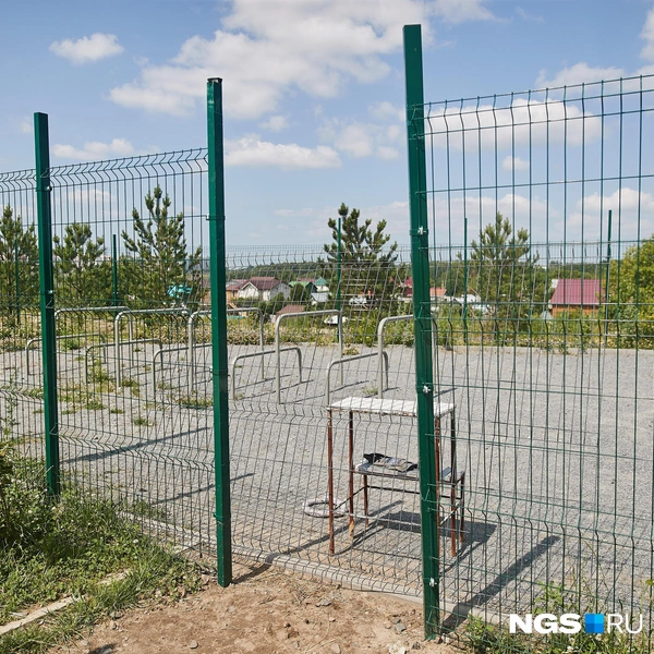 Дверь, которая закрывала площадку для выгула собак, сломалась — жители сами нашли часть железного забора, чтобы прикрывать проход | Источник: Александр Ощепков / NGS.RU