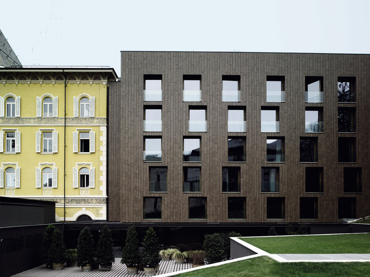 Лаконичный минималистский фасад Parc Hotel Billia контрастирует с соседним зданием гранд-отеля, построенным в стиле belle époque, популярном на рубеже XIX–XX веков.