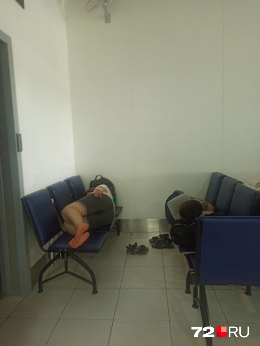 Взрослые пассажиры, утомленные долгим ожиданием, спят на креслах в зале ожидания | Источник: читатель 72.RU