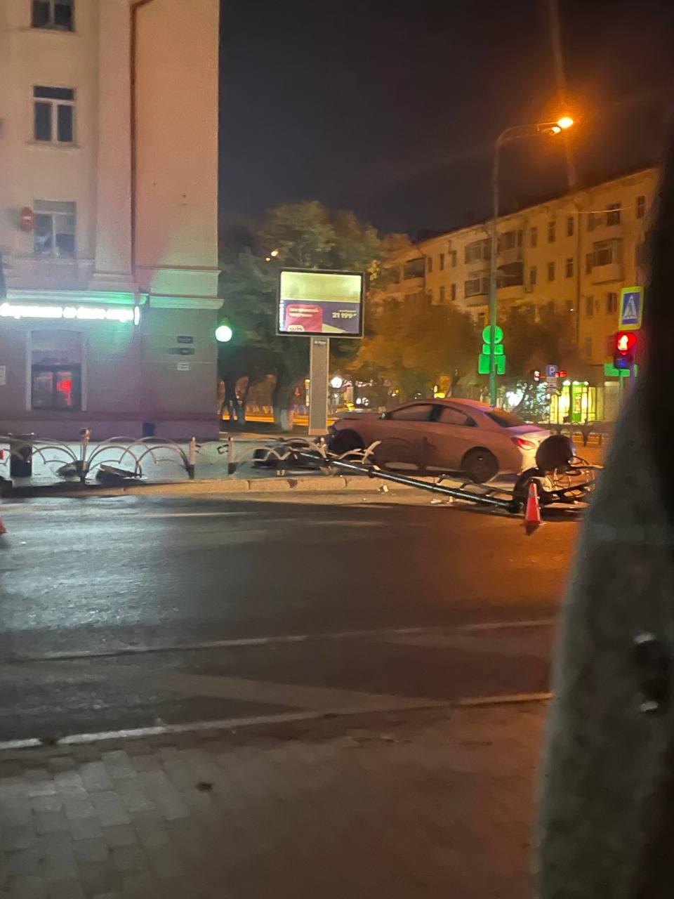 В центре Тюмени дорогой автомобиль пробил ограждение, снес столб и вылетел на тротуар — фото