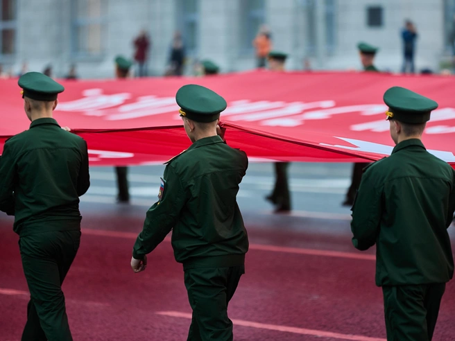 Военнослужащие пронесли увеличенную копию Знамени Победы | Источник: Александр Ощепков / NGS.RU