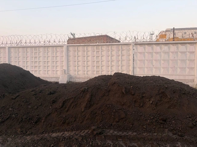 18 июня работали люди и спецтехника, которые выгружали землю на газон вдоль проезда Энергетиков | Источник: Настасья Медведева / NGS.RU