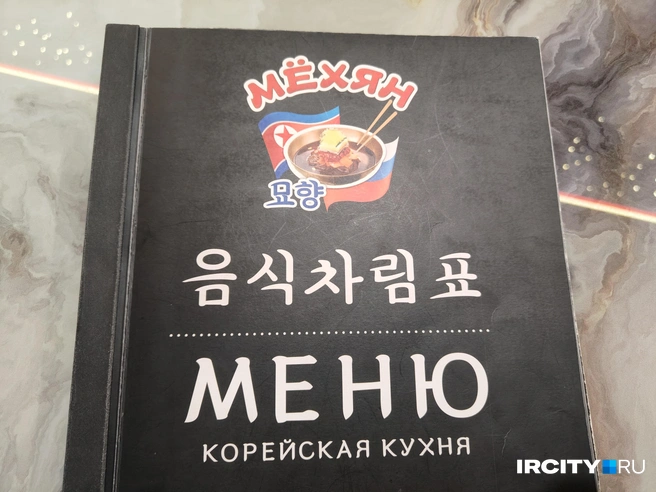 Флаг Северной Кореи можно увидеть и на входе в заведение, и на первой странице меню | Источник: Ксения Филимонова / «ИрСити»