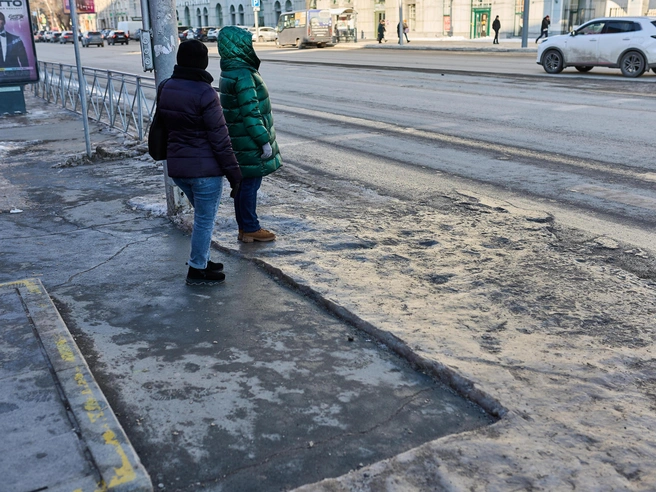 Тротуары в центре города покрыты ледяной коркой, но на некоторых участках лед убирают. | Источник: Александр Ощепков / NGS.RU