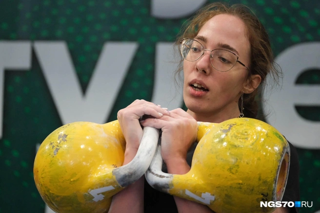 Спортсменка держит в руках две гири, вес каждой — 16 килограммов | Источник: Варвара Фролова / NGS70.RU