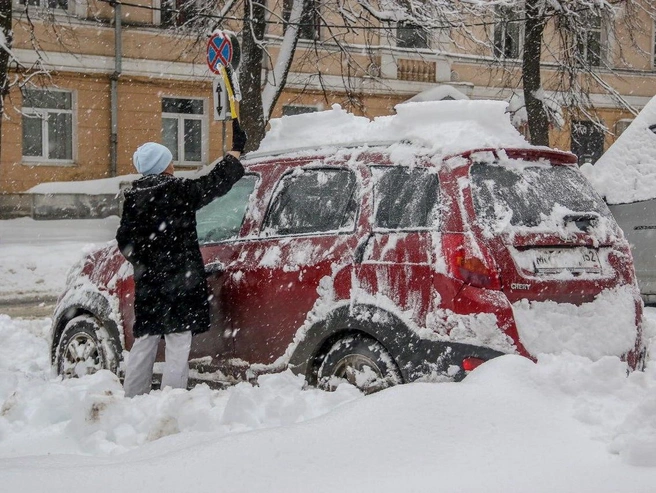 Автовладельцы стряхивали снег со своих машин. | Источник: Наталья Бурухина / NN.RU