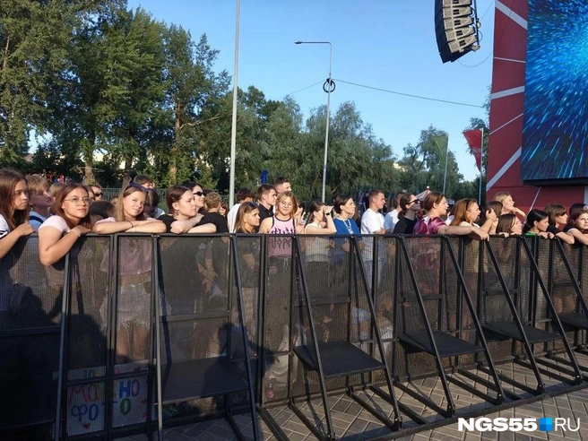 Ребята сели на землю и облокотились на забор | Источник: Ксения Сушко / NGS55.RU