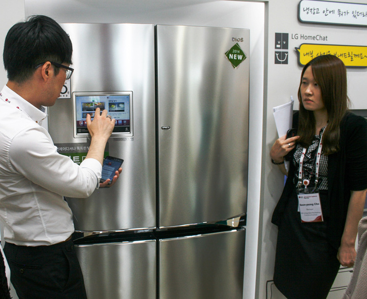 Сотрудник магазина показывает, как получить информацию о содержимом холодильника при помощи встроенного в дверцу ЖК-экрана или смартфона.