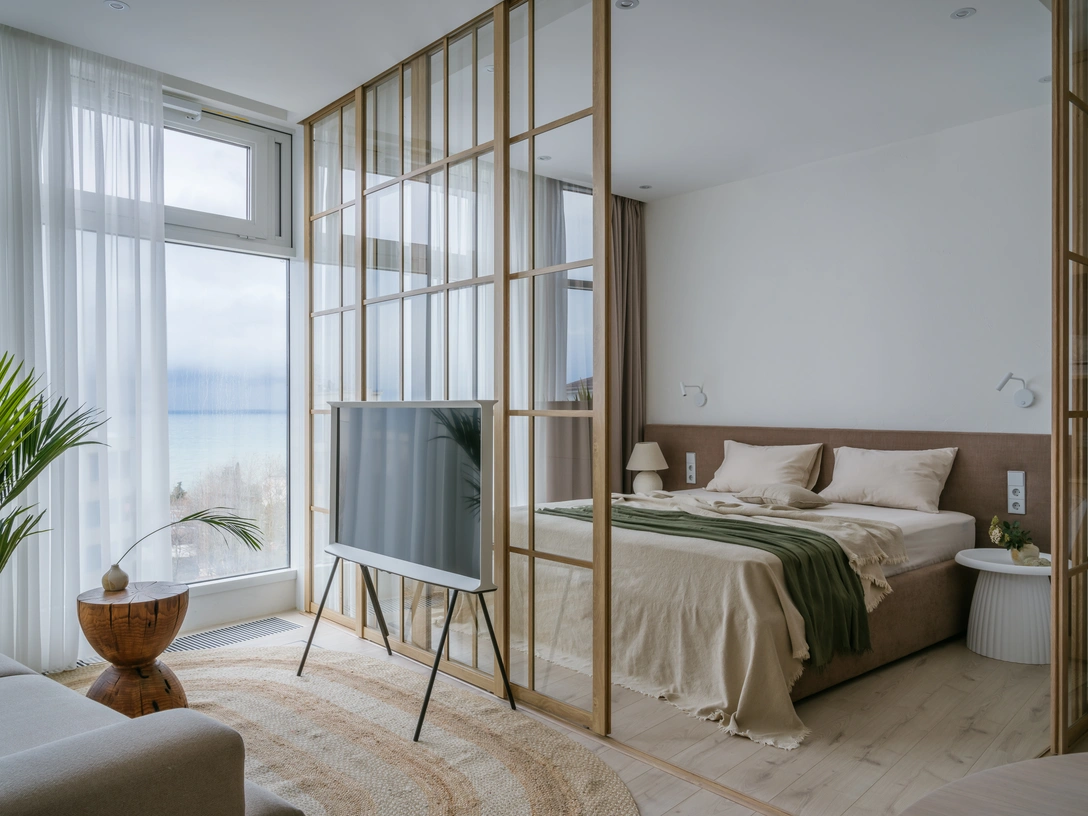 Вид из гостиной на спальню, отделенную стеклянными перегородками. Кровать выполнена на заказ специально для этого проекта. Телевизор, Samsung. | Источник: Михаил Чекалов. Стиль: Катя Клее