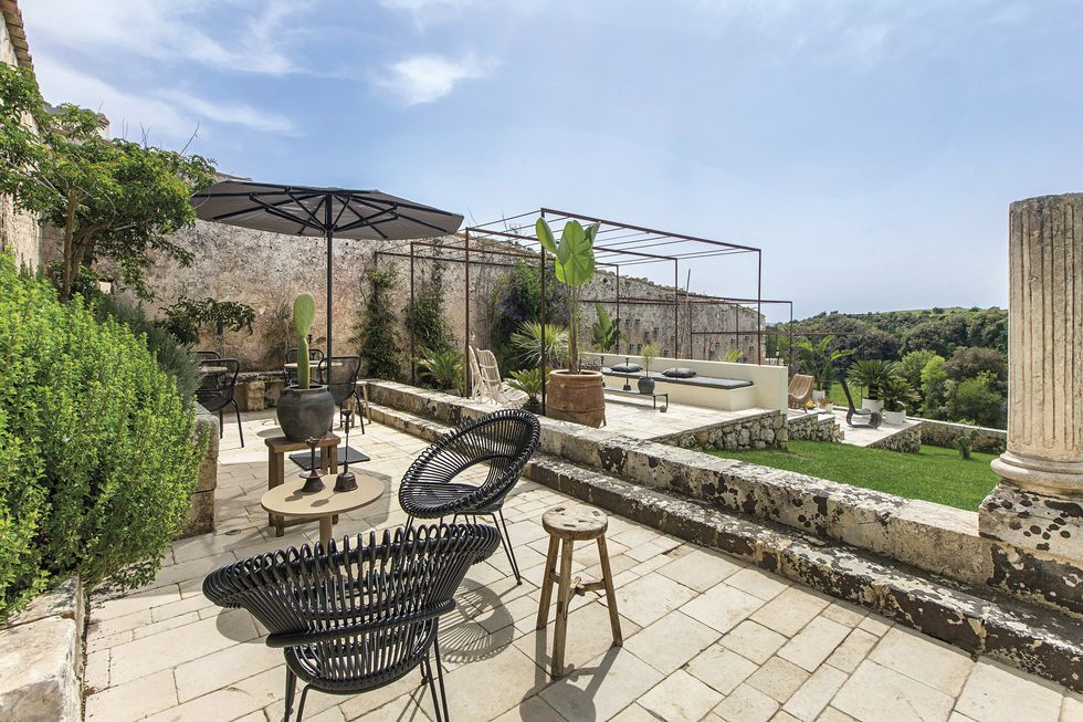 Терраса. Черные кресла Roy, Vincent Sheppard. Деревянные столики, Atmosphere, зонт, Kettal. | Источник: Маттиа Аквила