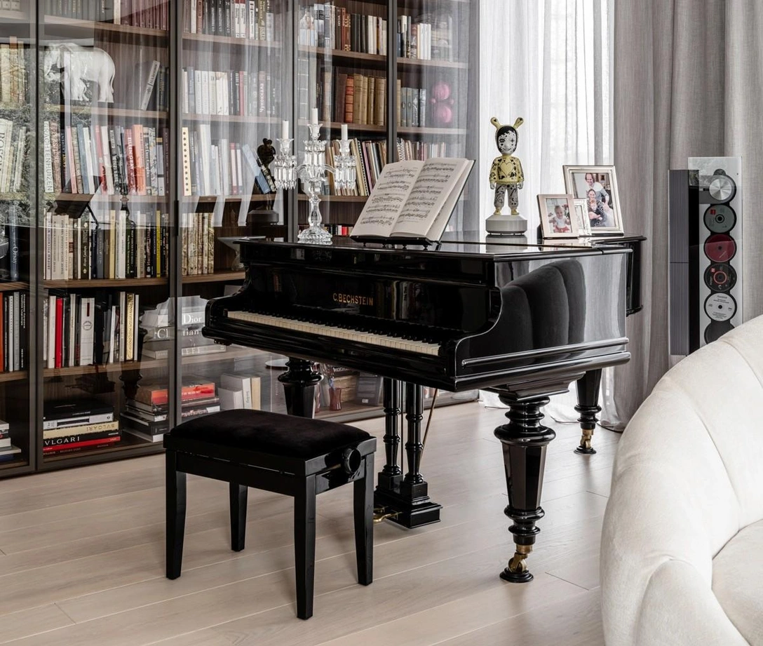 Гостиная, фрагмент. Антикварный рояль Bechstein начала XX века — один из немногих предметов, перевезенных из предыдущей квартиры. Библиотека, Caccaro. Винтажный проигрыватель BeoSound 9000, Bang & Olufsen. | Источник: Михаил Лоскутов. Стиль: Дарья Ишкараева