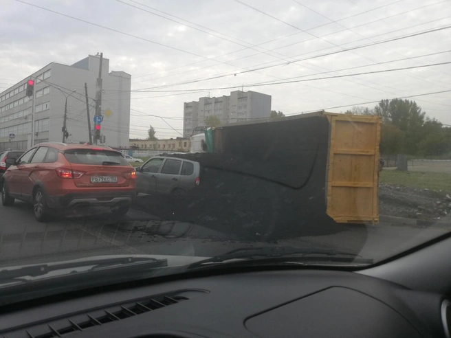 Легковой автомобиль оказался буквально погребён под слоем свежего асфальта | Источник: Игорь Аксёнов