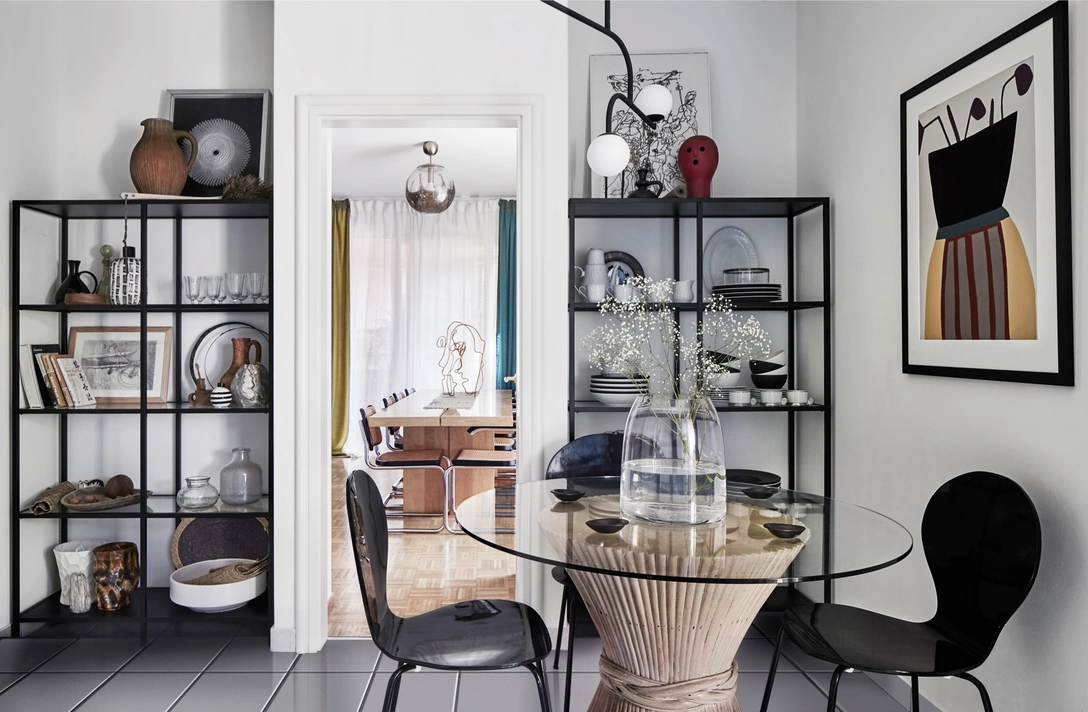 Обеденная зона на кухне. Стол сделан из винтажной ротанговой опоры, дополненной стеклянной столешницей. Стулья, винтаж. На стене — цветной принт от украинской художницы Ольги Фрадиной. Подвесной светильник, Pholc. | Источник: ФИЛИППО БАМБЕРГИ (Filippo Bamberghi)