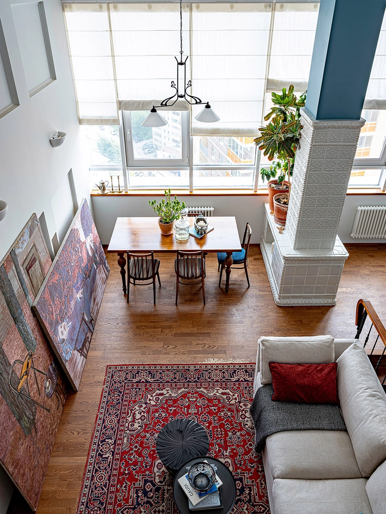 Кухня-гостиная. Несущую колонну облицевали изразцами и превратили в подобие печи, внутри которой прячется бар. Диван, Meridiani. Журнальные столики, Alivar и Kartell. Ковер, люстра и стулья, винтаж. | Источник: Петр Маслов