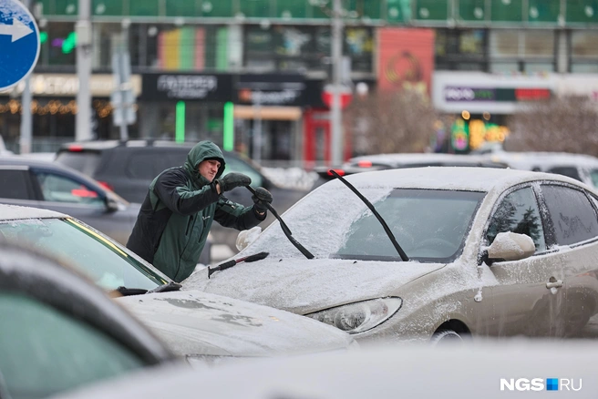 Водителям приходится очищать стекла автомобилей от наледи | Источник: Александр Ощепков / NGS.RU