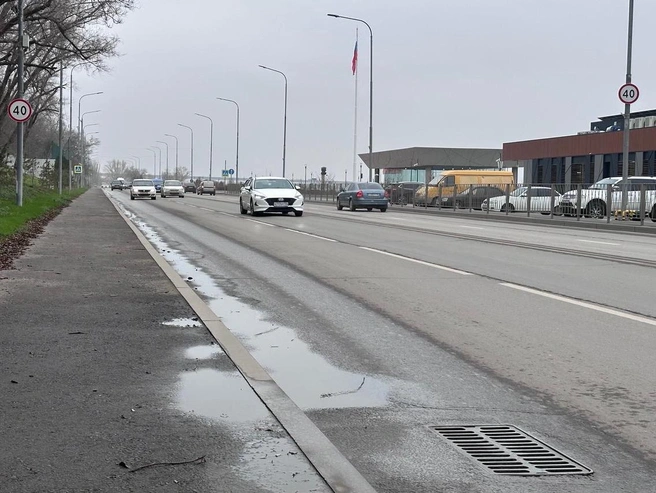 Водные потоки стекают по дорожному полотну, не попадая в колодцы ливневой канализации. | Источник: Алексей Волхонский / V1.RU