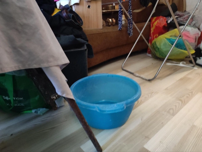 Тазы и ведра расставлены по всей квартире для сбора воды с потолка. | Источник: Денис Паустовский / V1.RU