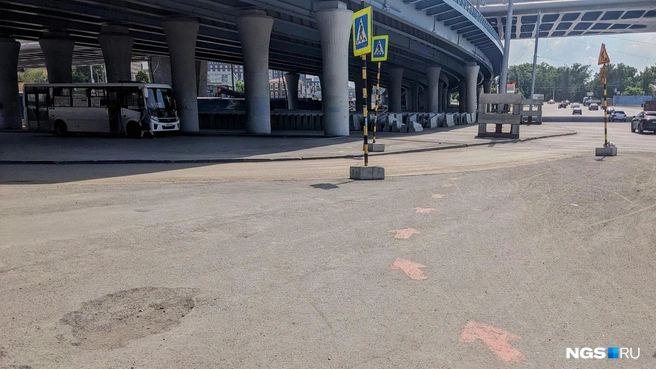 Стрелочки предлагают идти прямо туда, в сумерки подмостовья, и теряются где-то в асфальте под эстакадой | Источник: Лиза Пичугина / NGS.RU
