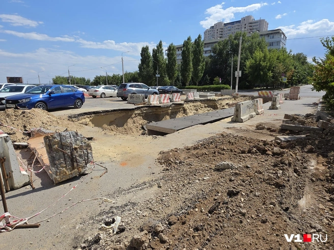 Остатки сигнальной ленты, огораживающей яму, треплет ветер по асфальту | Источник: Константин Завриков / V1.RU