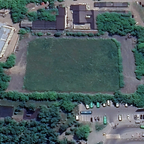 2025 год. Разрешение современных спутников позволяет посмотреть на стадион поближе. Видно, что трибуны заросли деревьями и кустарниками, да и само поле поросло травой | Источник: Google Earth