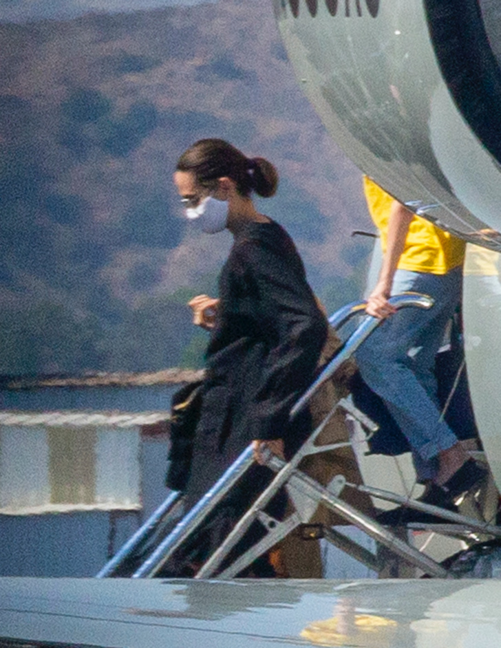Даже во время перелета — в черном шелке: Анджелина Джоли с детьми в аэропорту